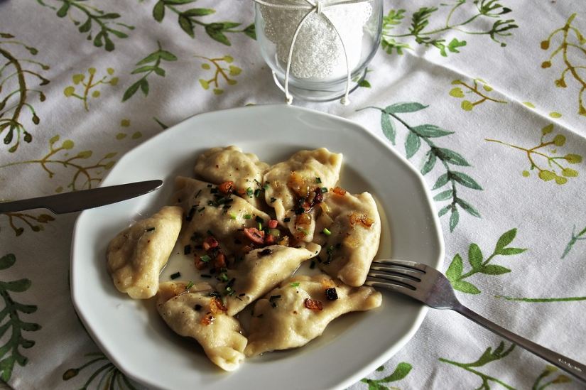 cooked pierogi, plate, knife, fork, tablecloth, glass, table napkin