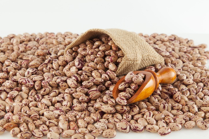 Pinto beans, a legume native to the American continent; photo on white background.