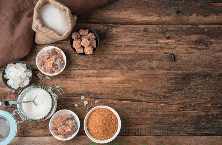 Sugar in a large assortment on a wooden background. Top view with copy space