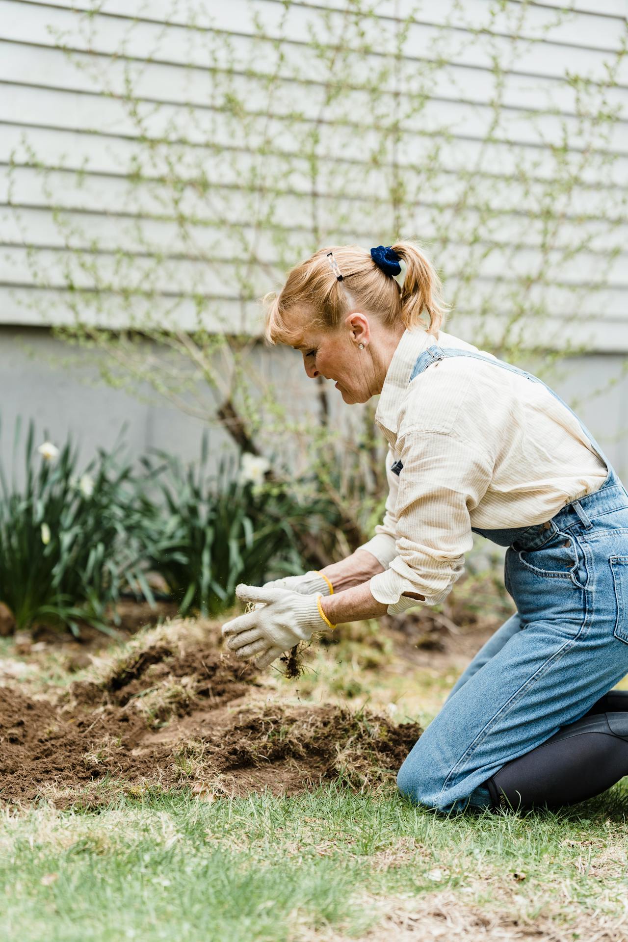 a woman removing grass from the soil
