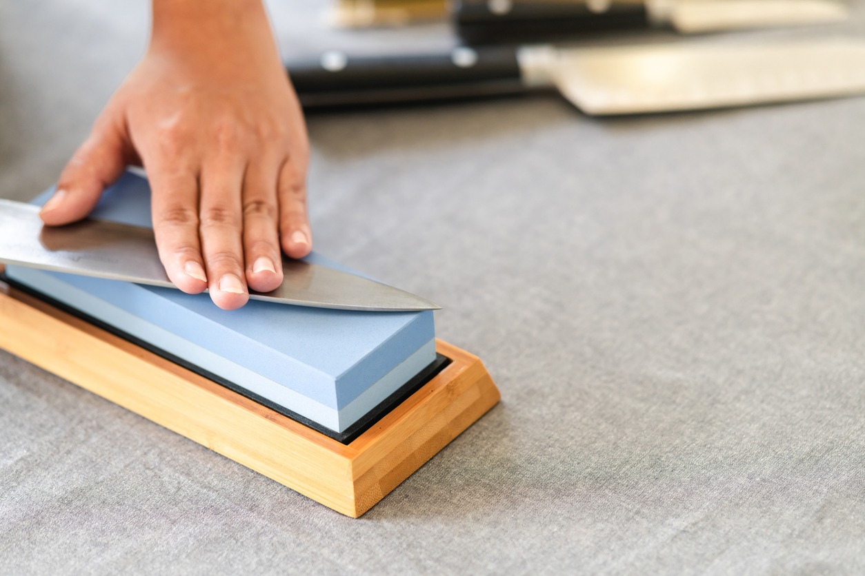Chef sharpening knife on table