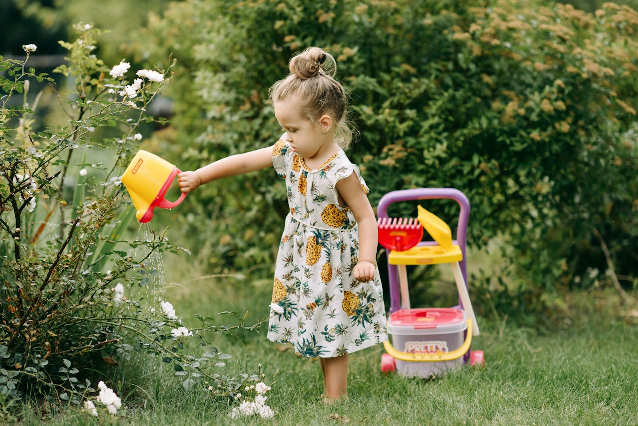 a young girl watering a plant