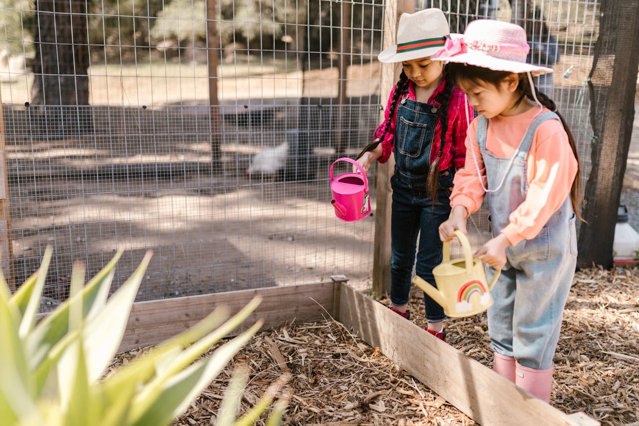 two young girls watering plants
