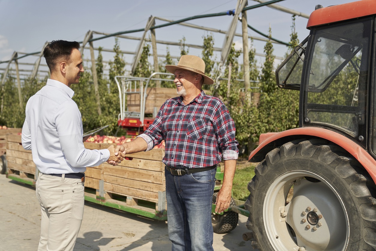 Successful transaction between senior farmer and sales representative