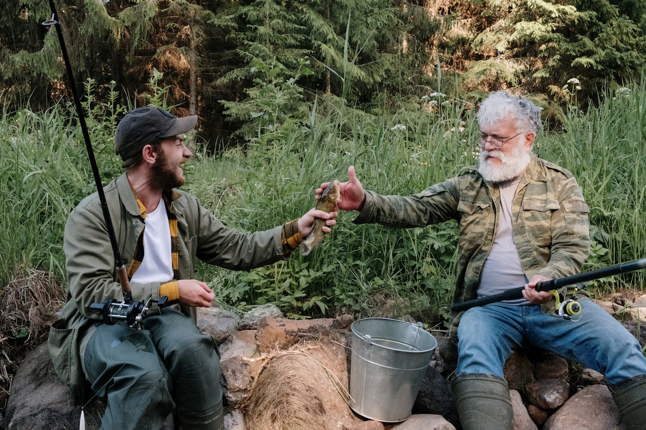 adult son and senior dad admiring their caught fish