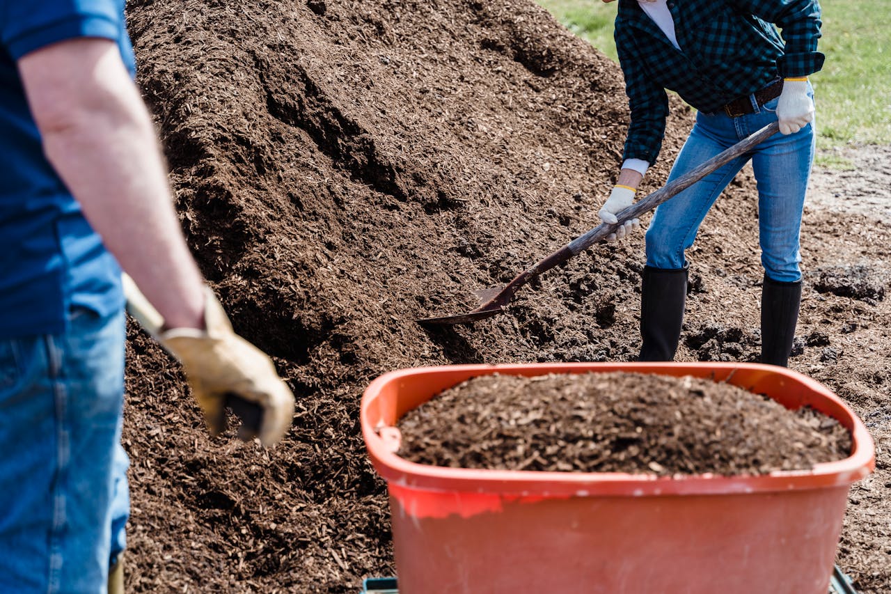 a person holding a shovel while shoveling the soil
