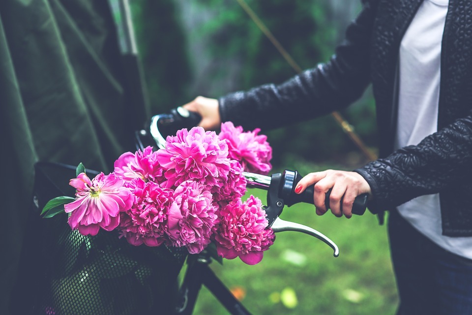 Image of a woman with flowers on a cycle.