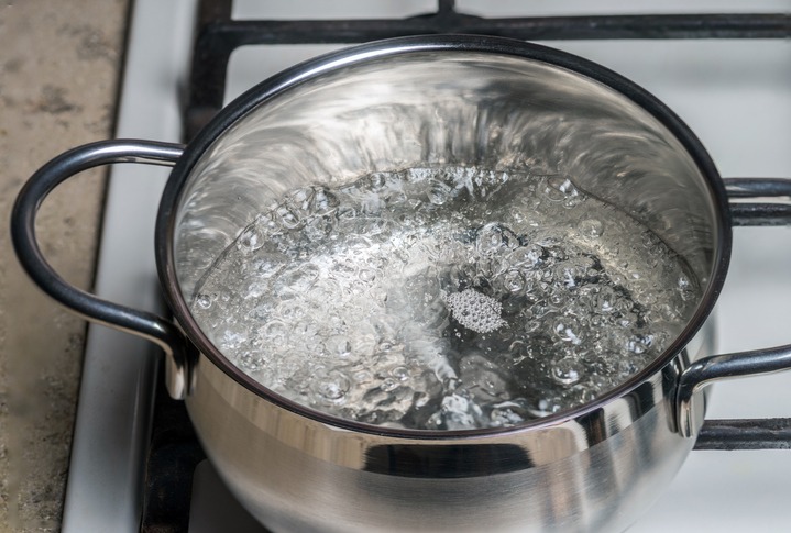 Boiling water in a stainless saucepan on a gas