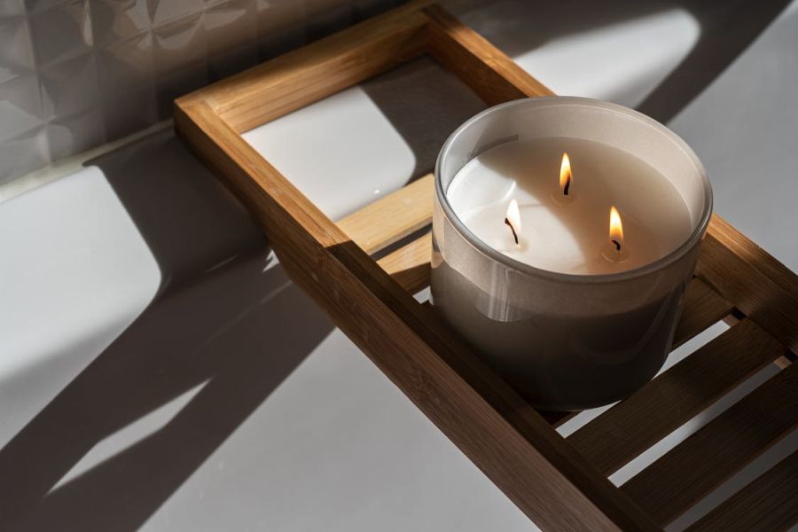 a candle burning on a wooden tray