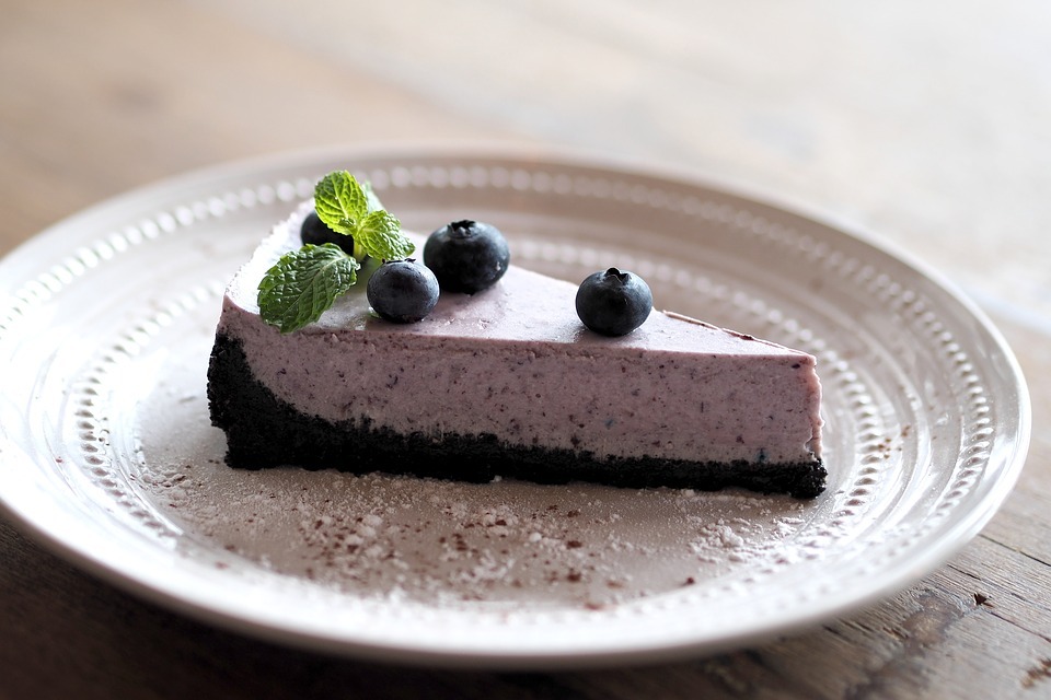 Image of a slice of a blueberry cheesecake.