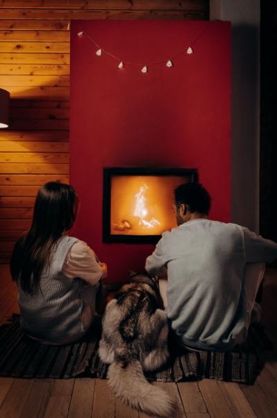couple-sitting-near-fireplace-with-their-dog